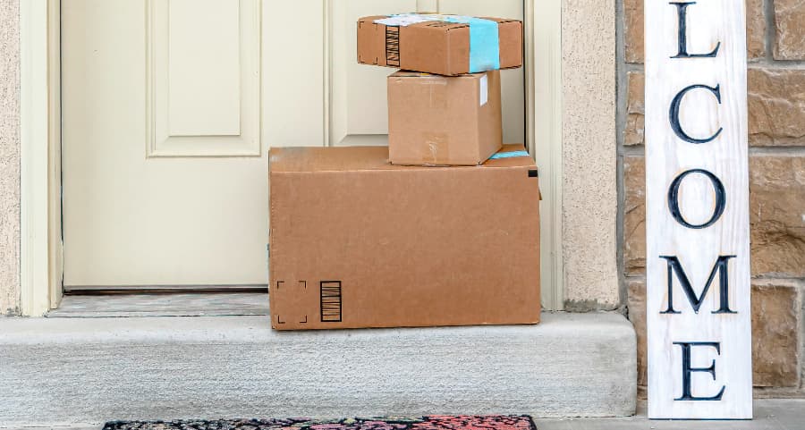 Packages on the doorstep of a home with a welcome sign in Plano