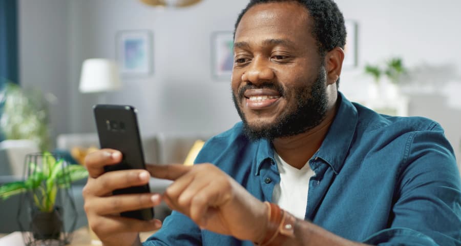 Man in his home using an app on his smartphone